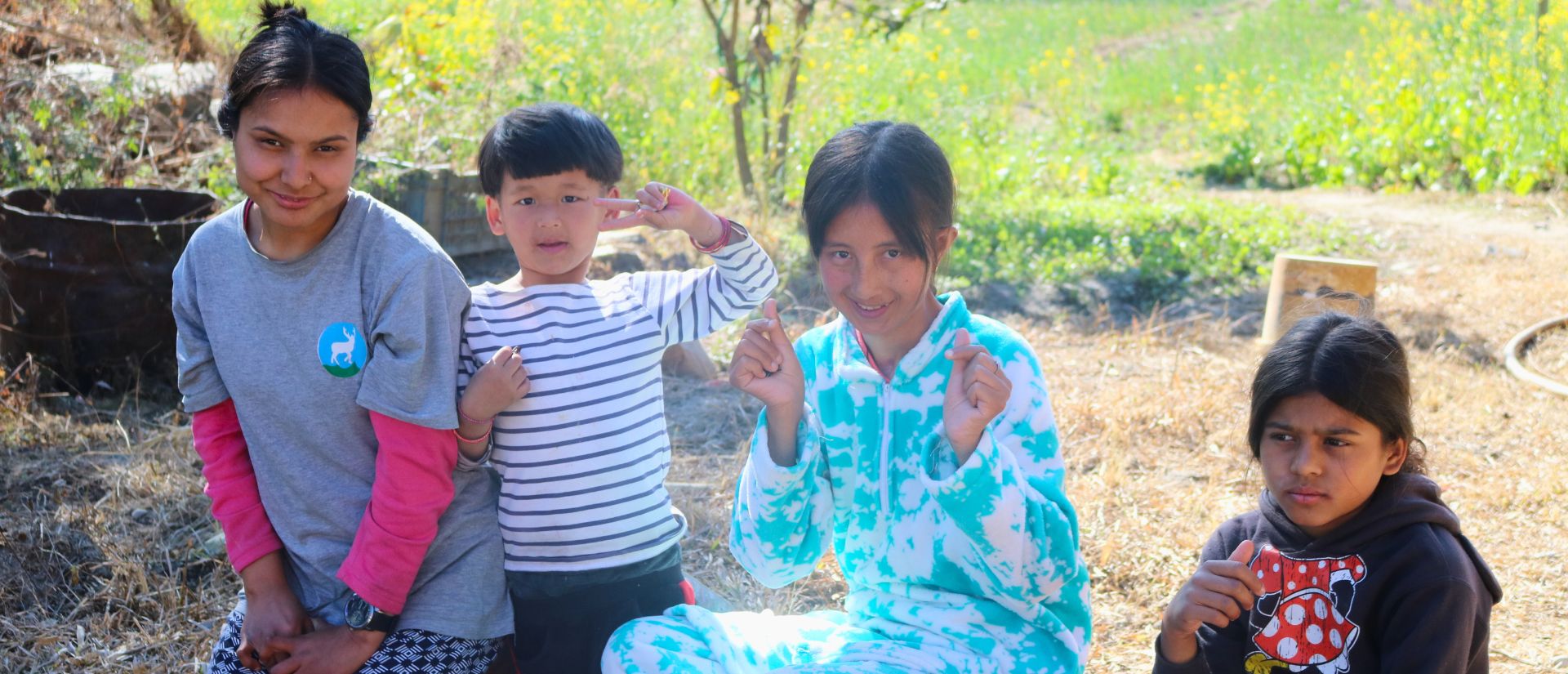 Eine Gruppe von jungen Frauen und Kindern sitzt lächelnd zusammen