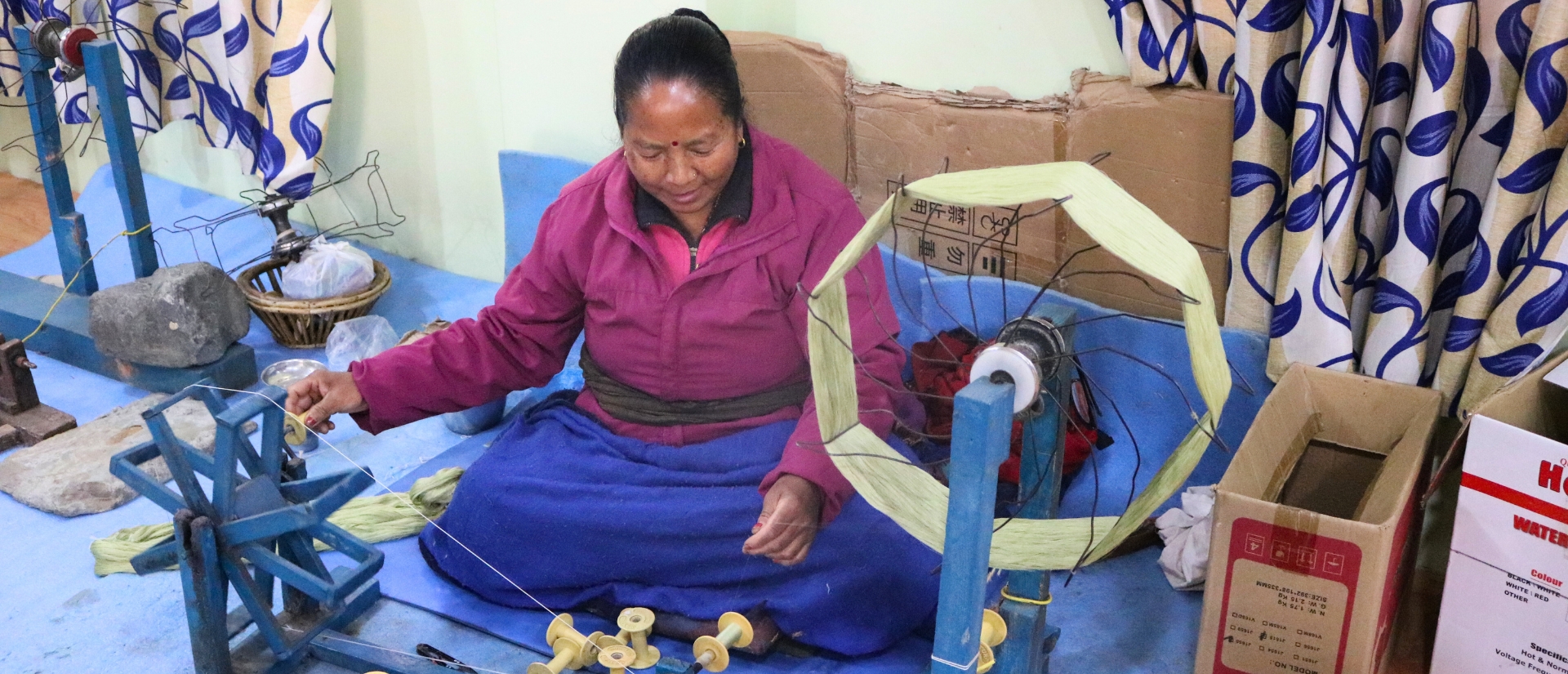 Eine Frau spult Garn über eine Maschine ab