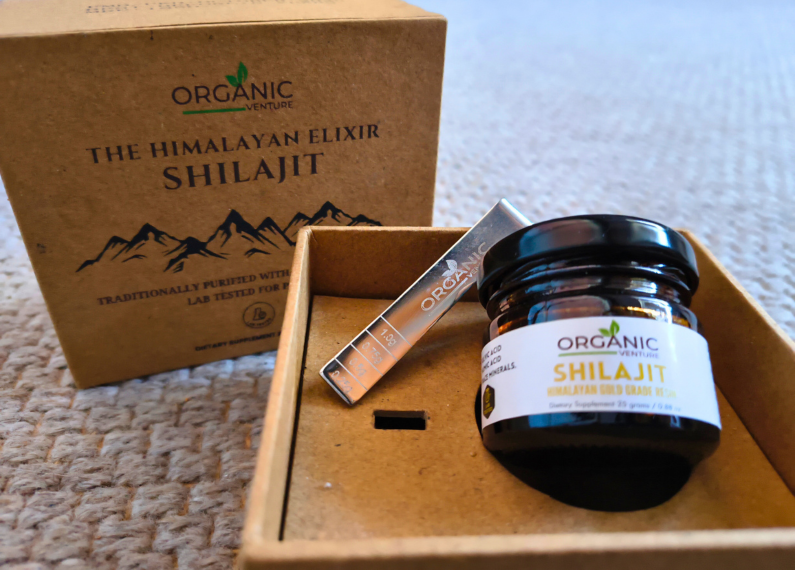 In einer geöffneten Box liegt ein Glas mit der Aufschrift Shilajit.