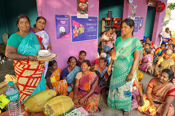 Frauen eines Spar- und Leihzirkels in Indien präsentieren recyclebare Teller aus Baumrinde.