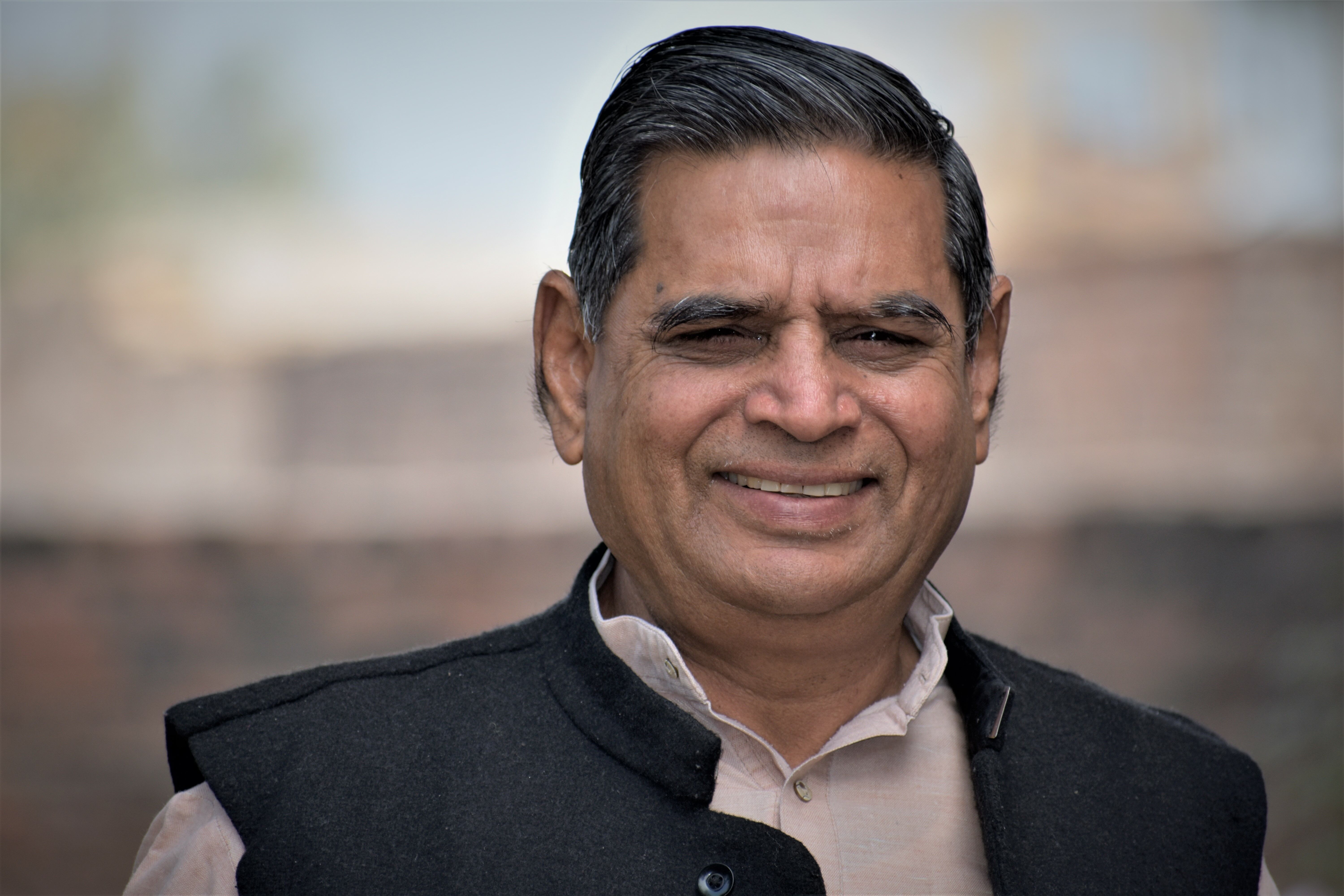 Porträtfoto von einem lächelnden Mann vor verschwommenem Hintergrund