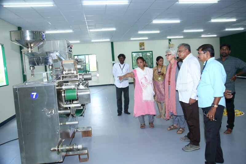 Lokale und internationale ExpertInnen betrachten eine Produktionsstraße, die zur Herstellung der Medikamente dient